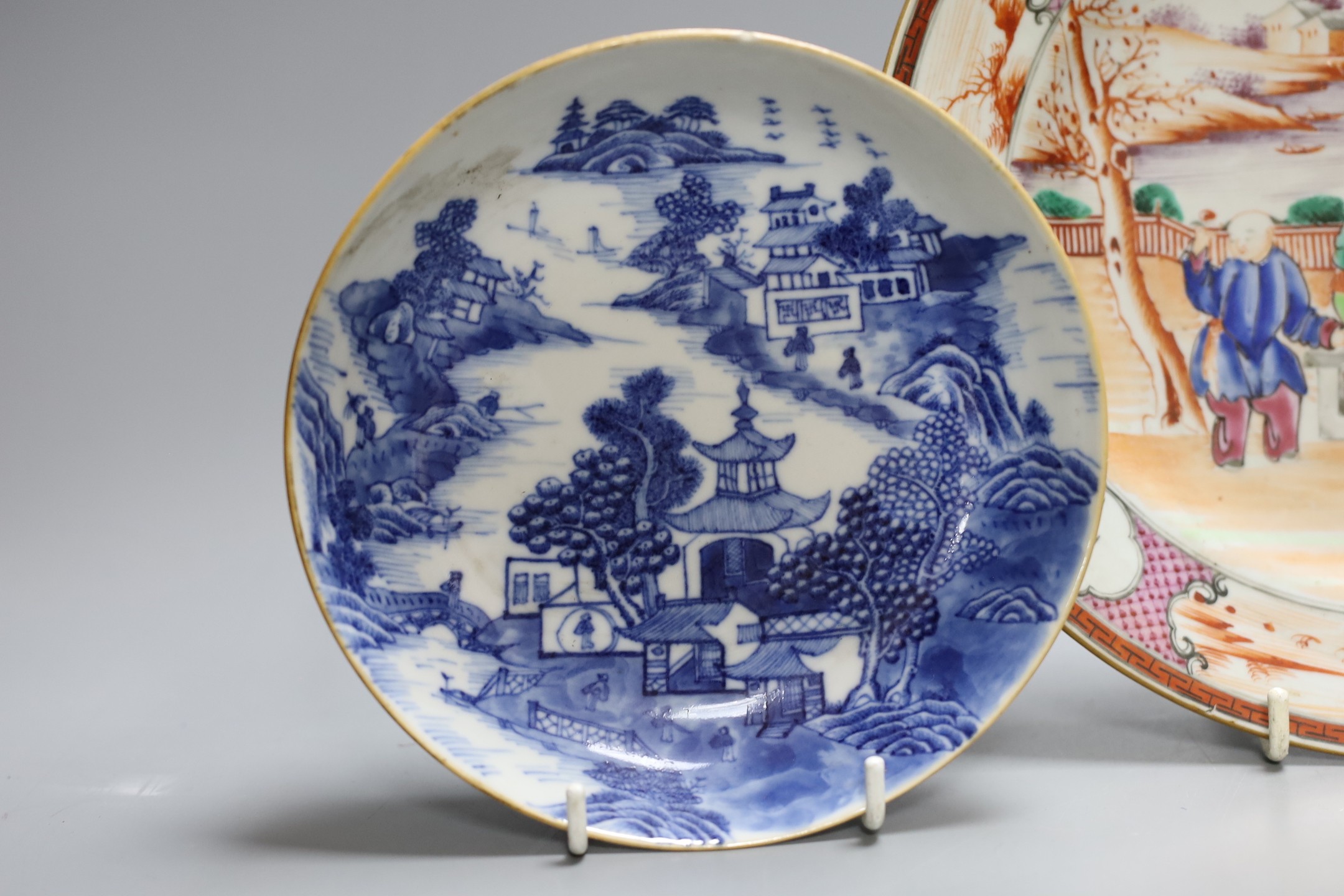 An 18th century Chinese export famille rose plate and two similar blue and white saucers, largest 23cm